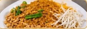 Pad thai with bean sprouts, crushed peanuts and lime, on a white plate