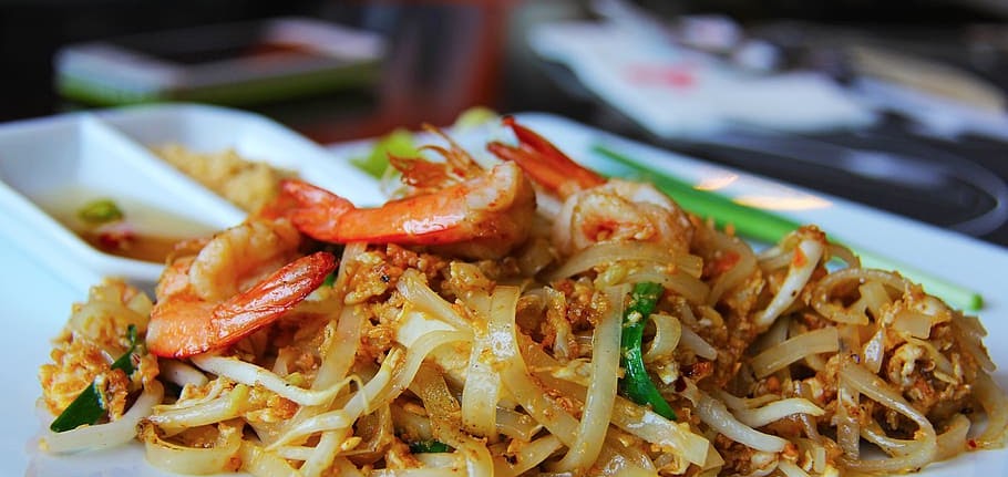 A plate of pad thai — rice noodles with shrimp, crushed peanuts, bean sprouts and green onion